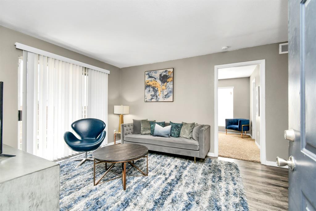 a living room with furniture a rug and a window