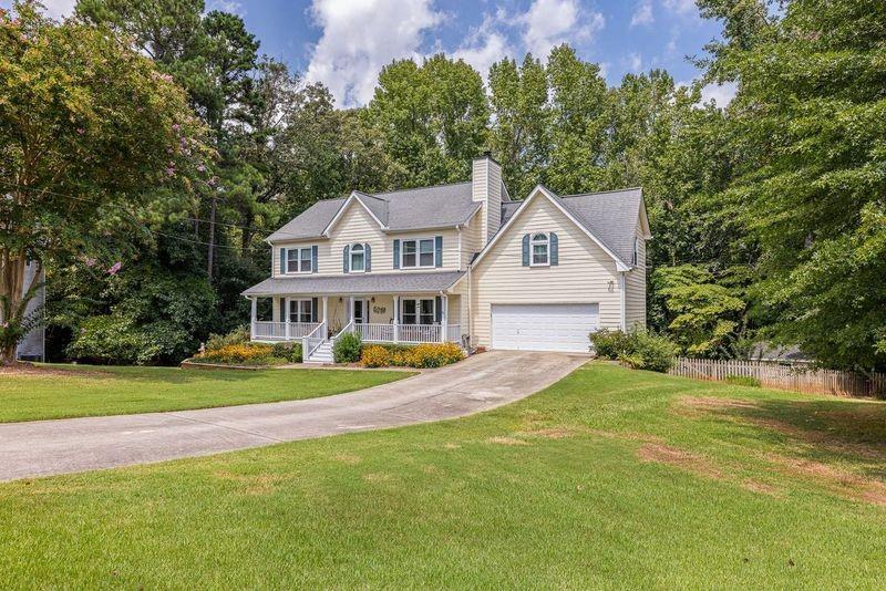 a view of a house with a big yard and large trees