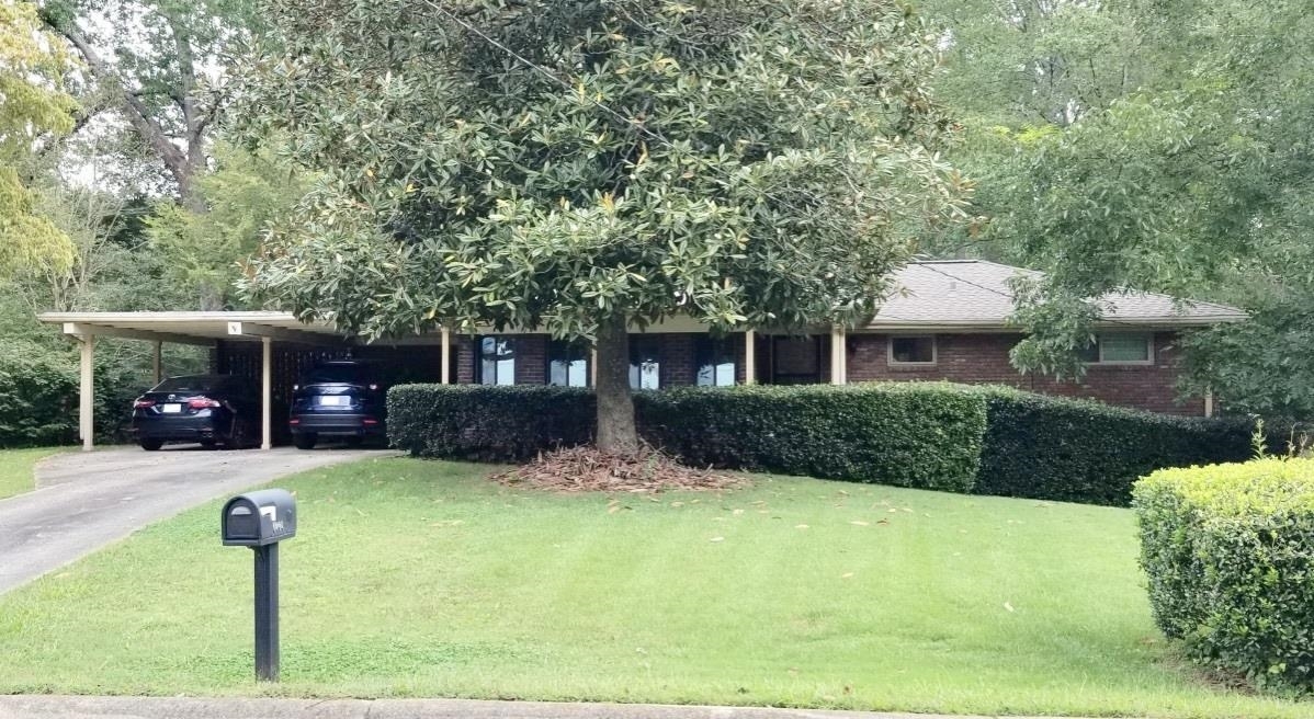 a front view of a house with a yard and potted plants