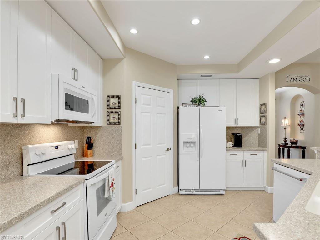 a kitchen with stainless steel appliances a refrigerator sink and white cabinets