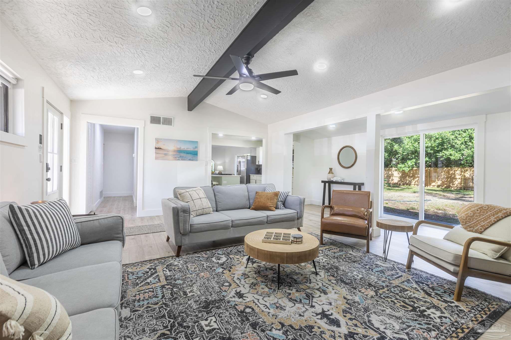 a living room with furniture a rug and a window