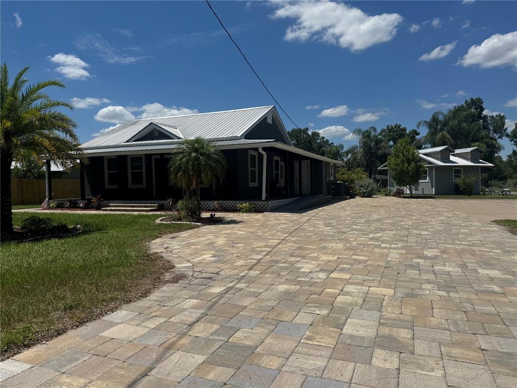 a view of the house with backyard and trees