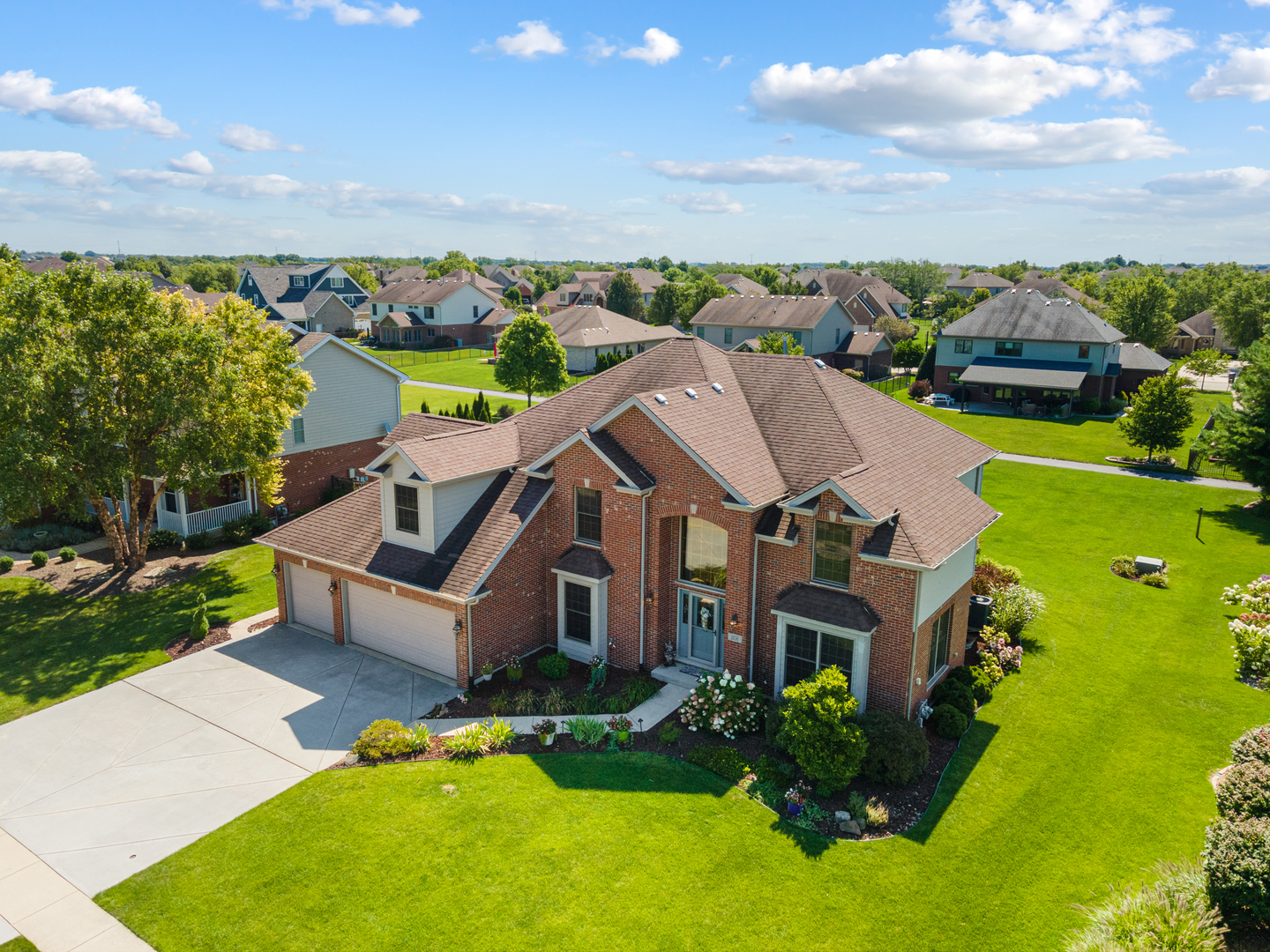 an aerial view of a house with a garden and lake view