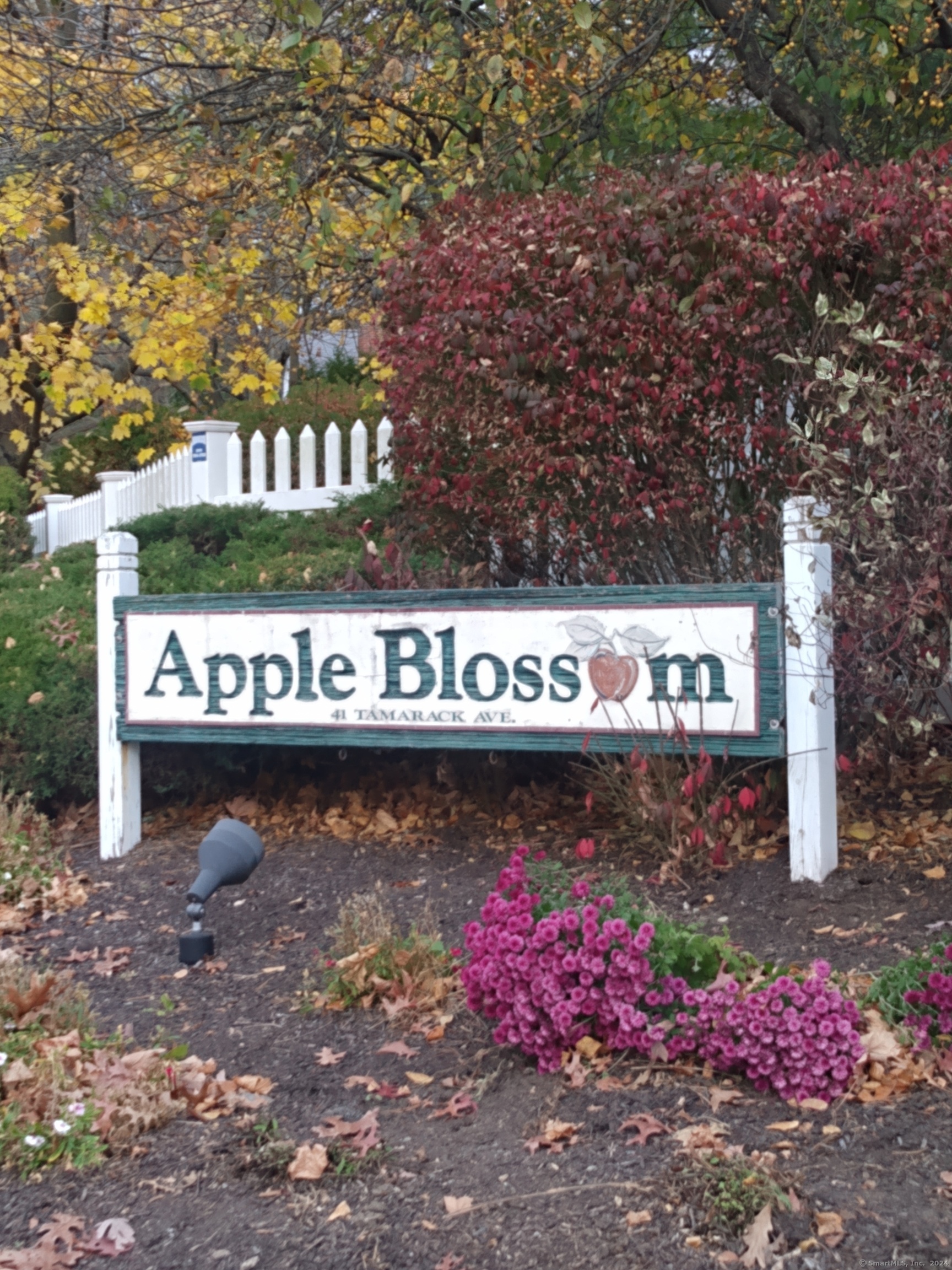 a street sign that is sitting in front of flowers