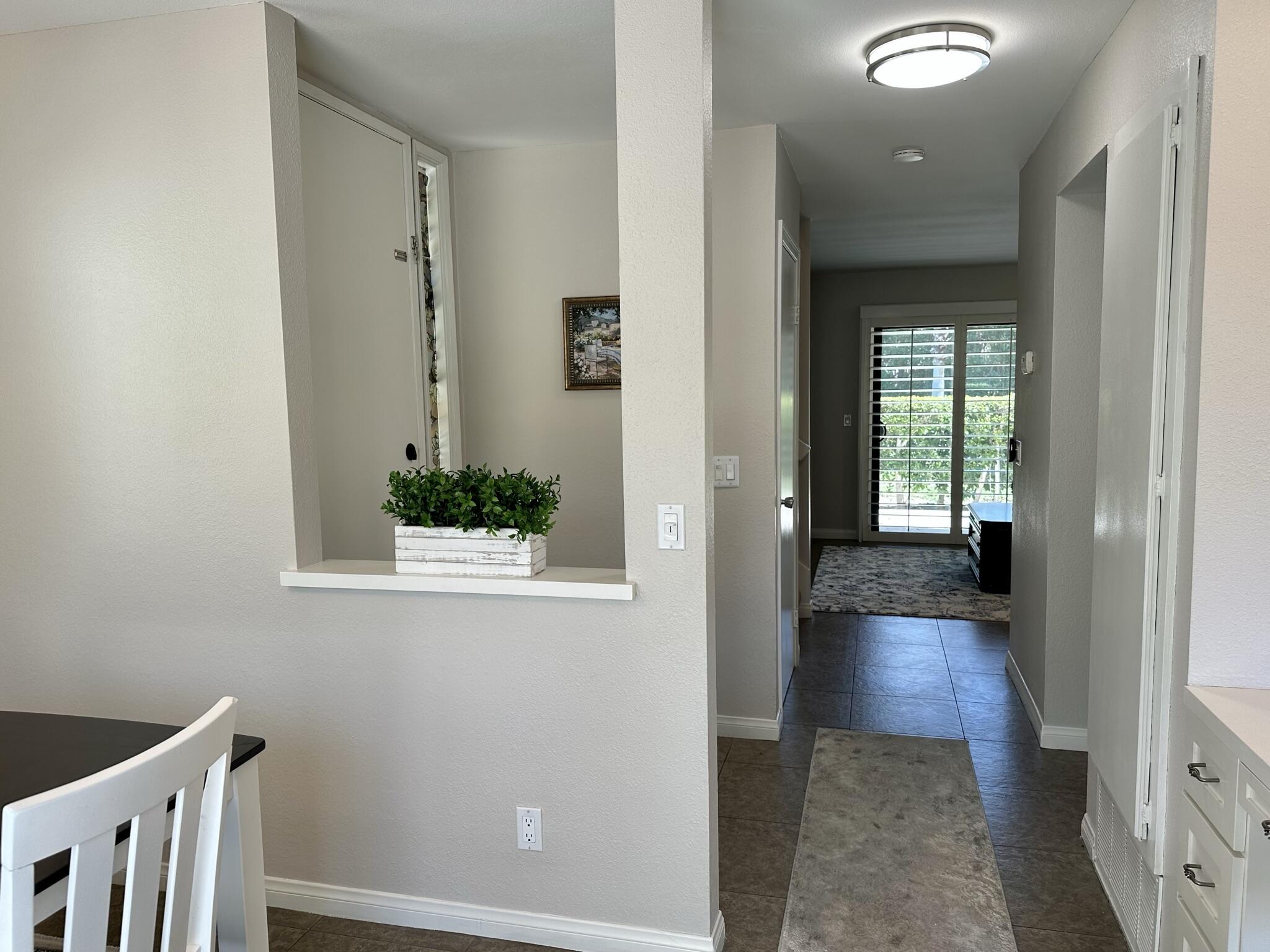 a view of a hallway with wooden floor and a bathroom