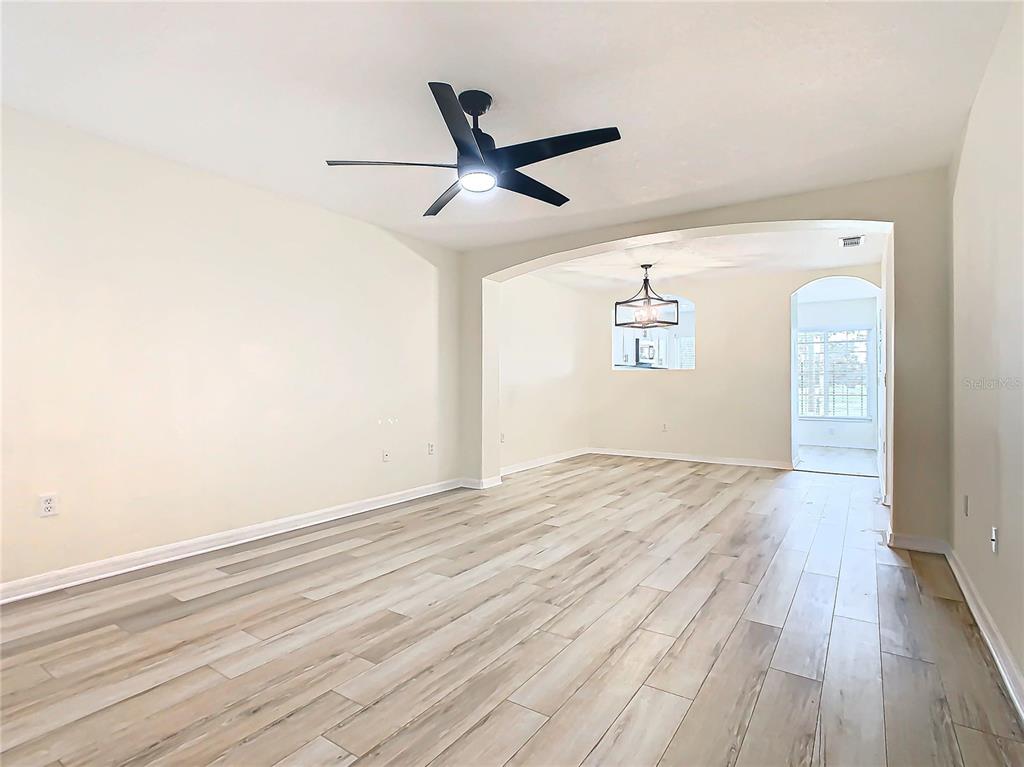 an empty room with wooden floor a ceiling fan and wooden floor