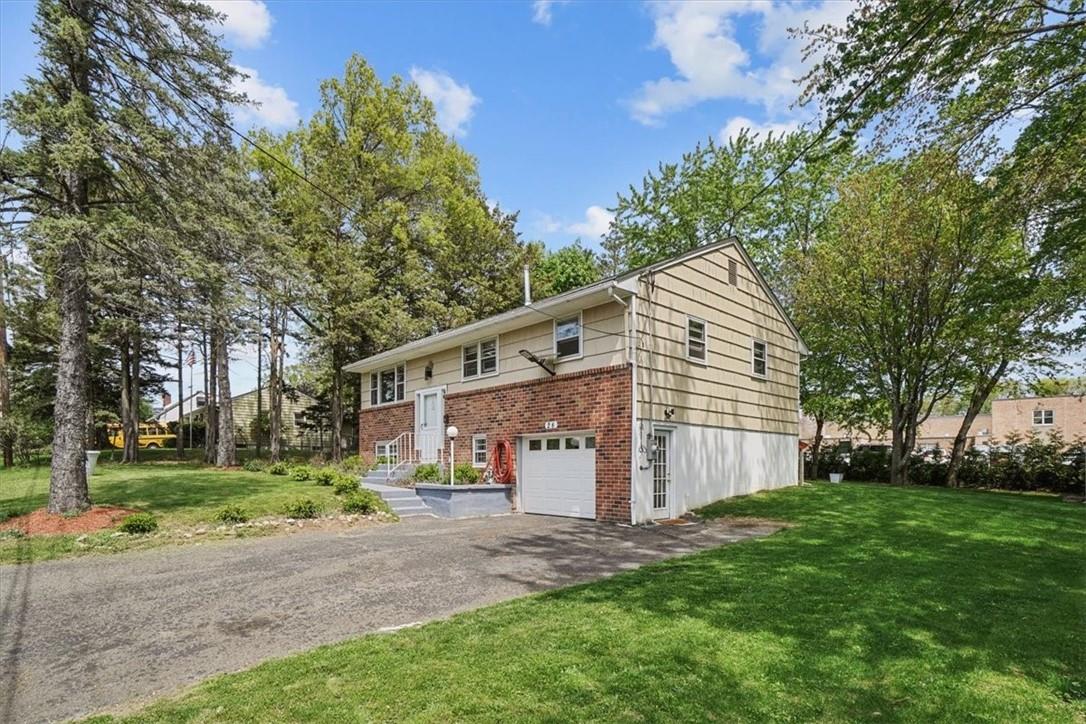 Bi-level home with a front yard and a garage