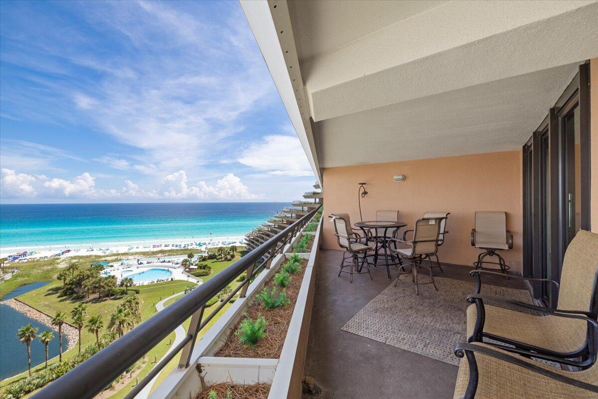 a view of a balcony with chairs and wooden floor