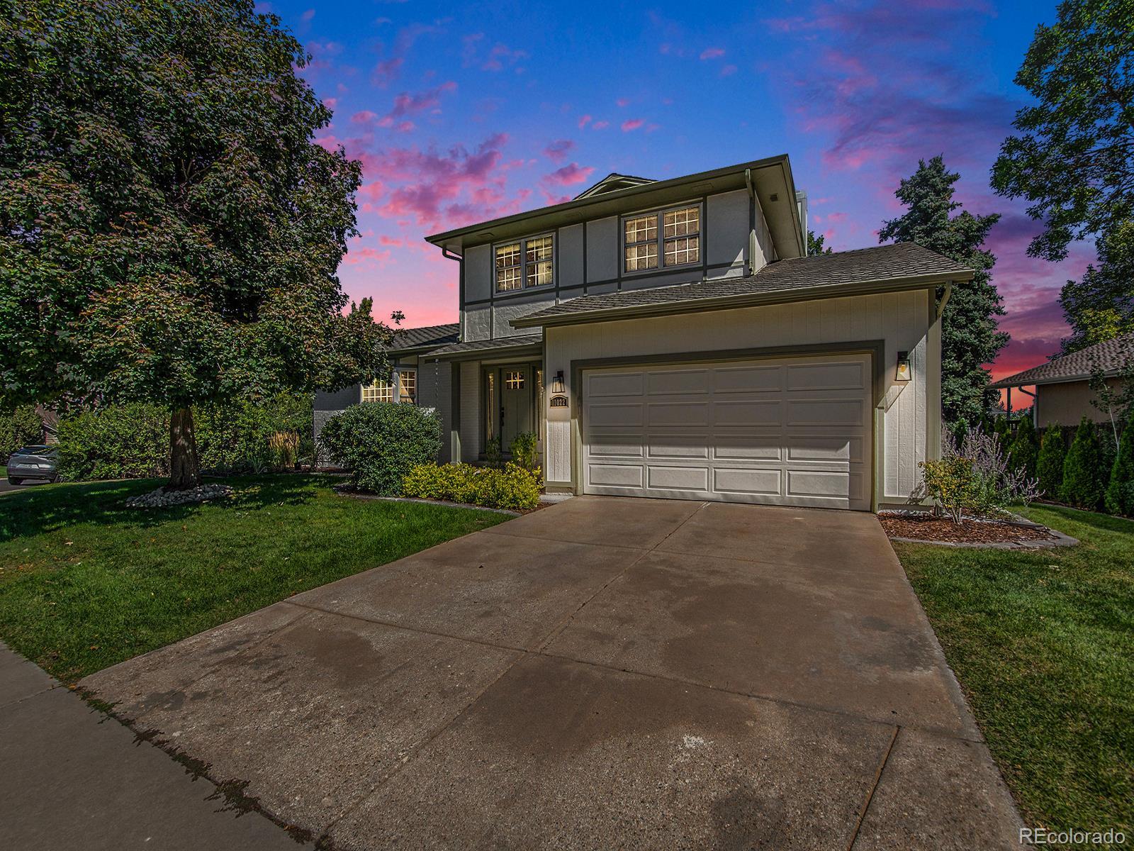 a front view of a house with a garden and garage