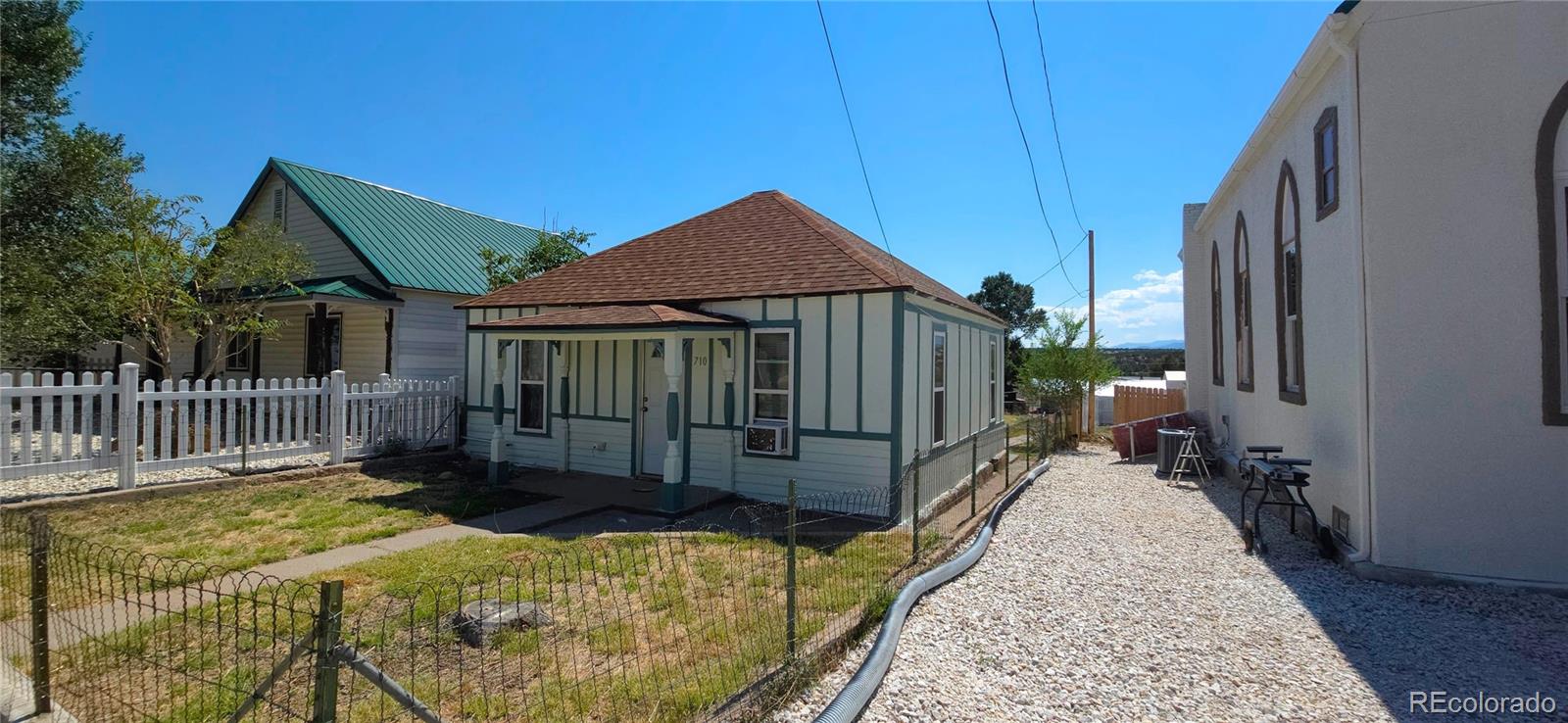 a view of a house with a small yard and wooden fence