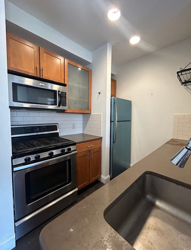 a kitchen with granite countertop a stove and a microwave