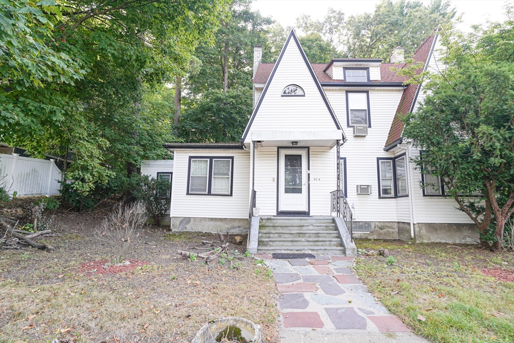 a front view of a house with a yard and trees