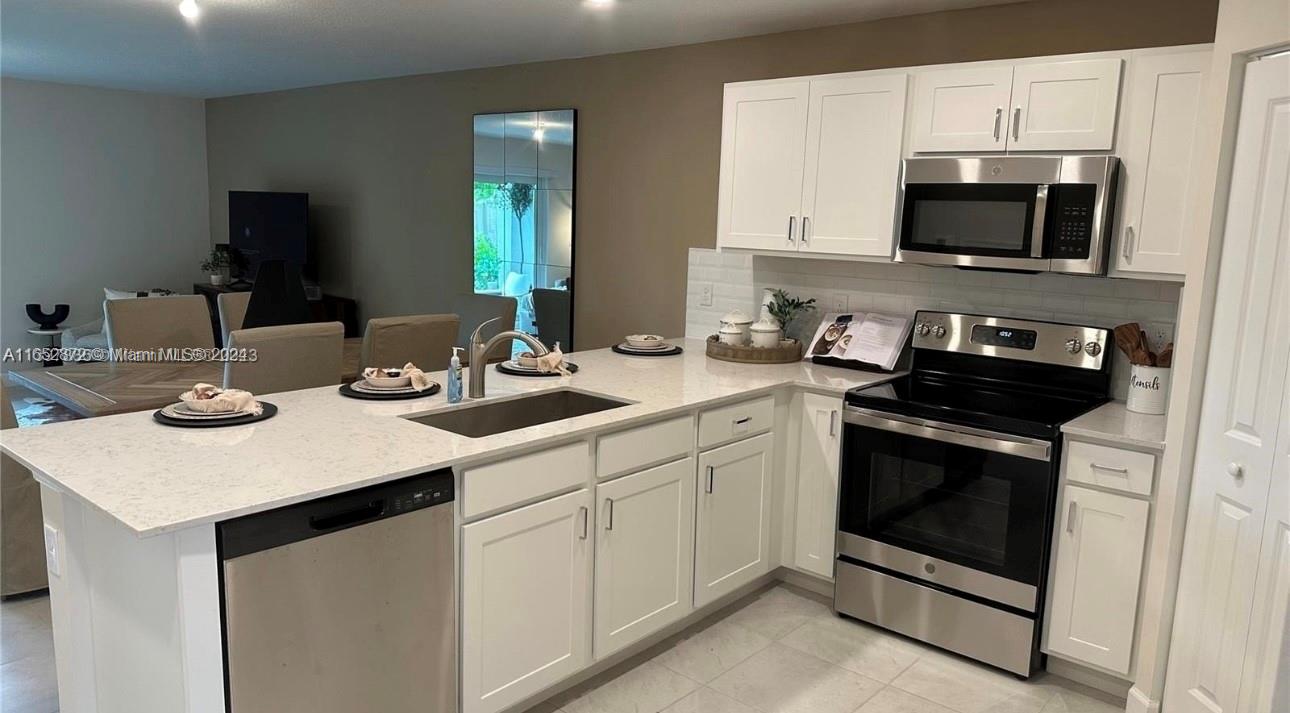 a kitchen with a sink stove and microwave