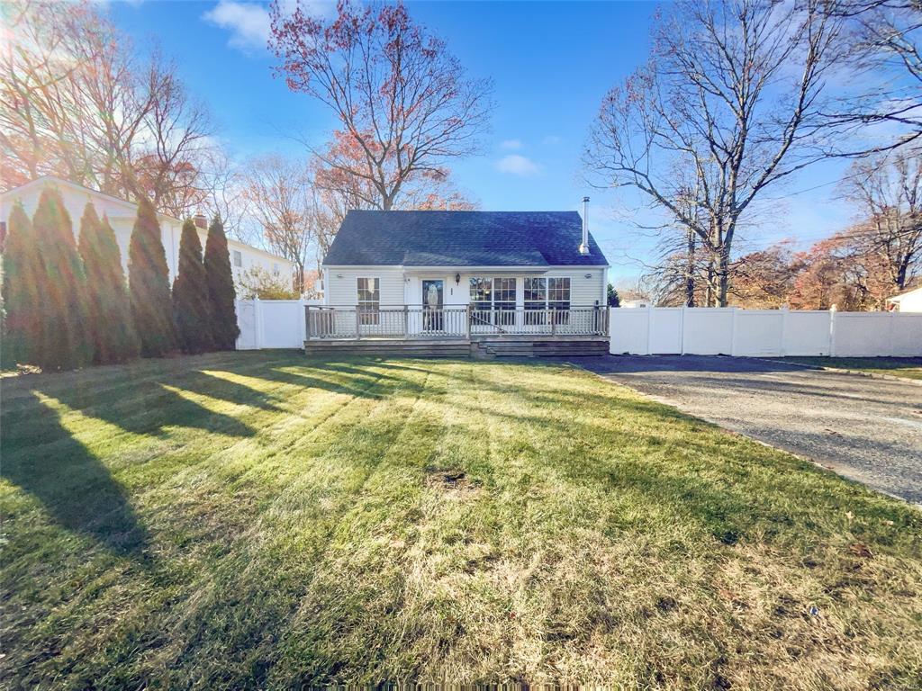 Back of property featuring a lawn and a deck