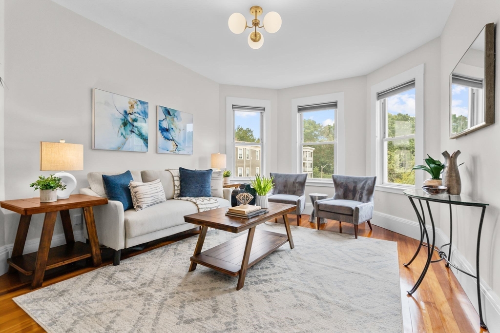 a living room with furniture a chandelier and a window