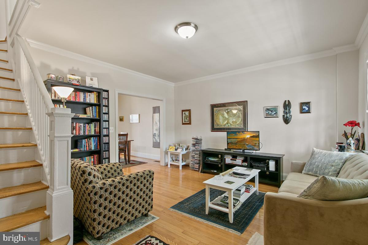 a living room with furniture a couch and a bookshelf with wooden floor