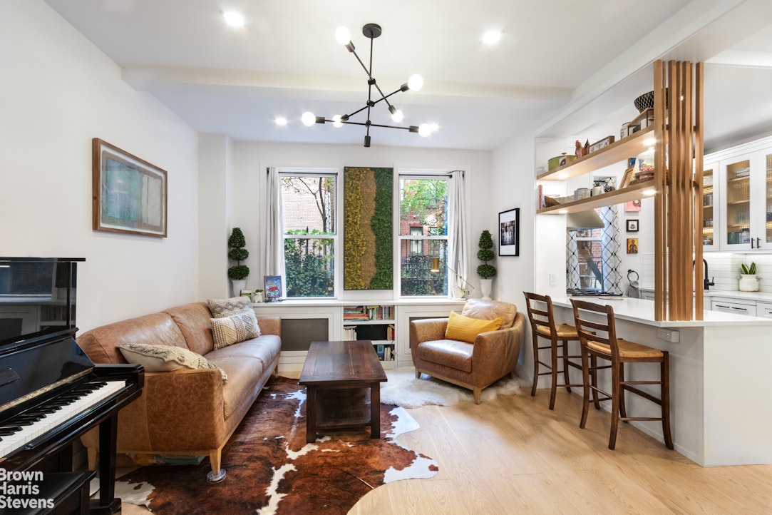 a living room with furniture ceiling fan and a large window