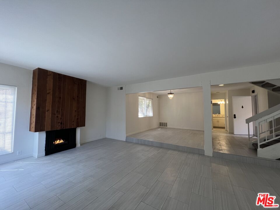 an empty room with a window and a fireplace