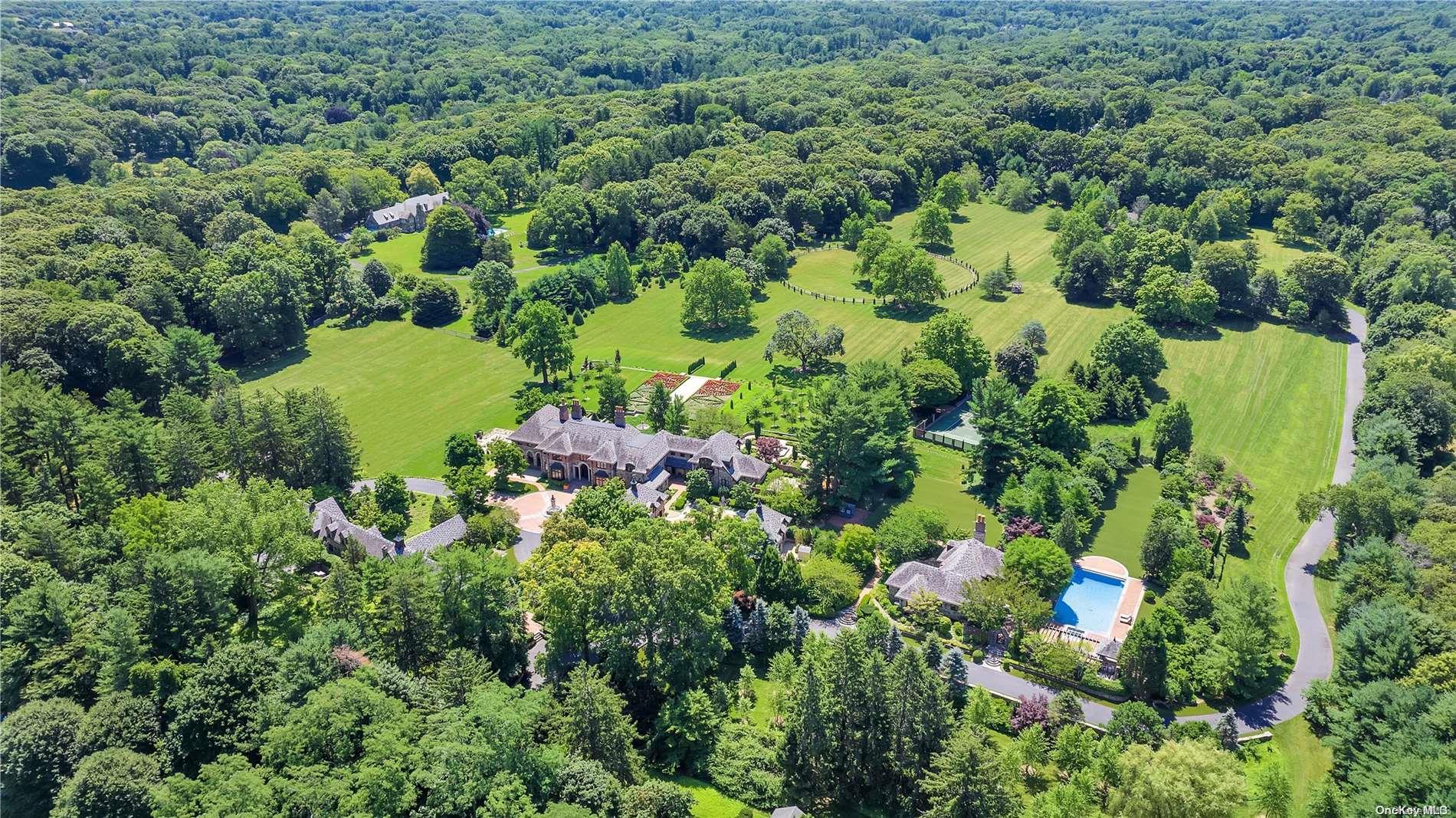 an aerial view of residential house with outdoor space and trees all around