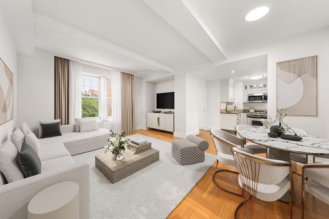 a living room with furniture kitchen view and a window