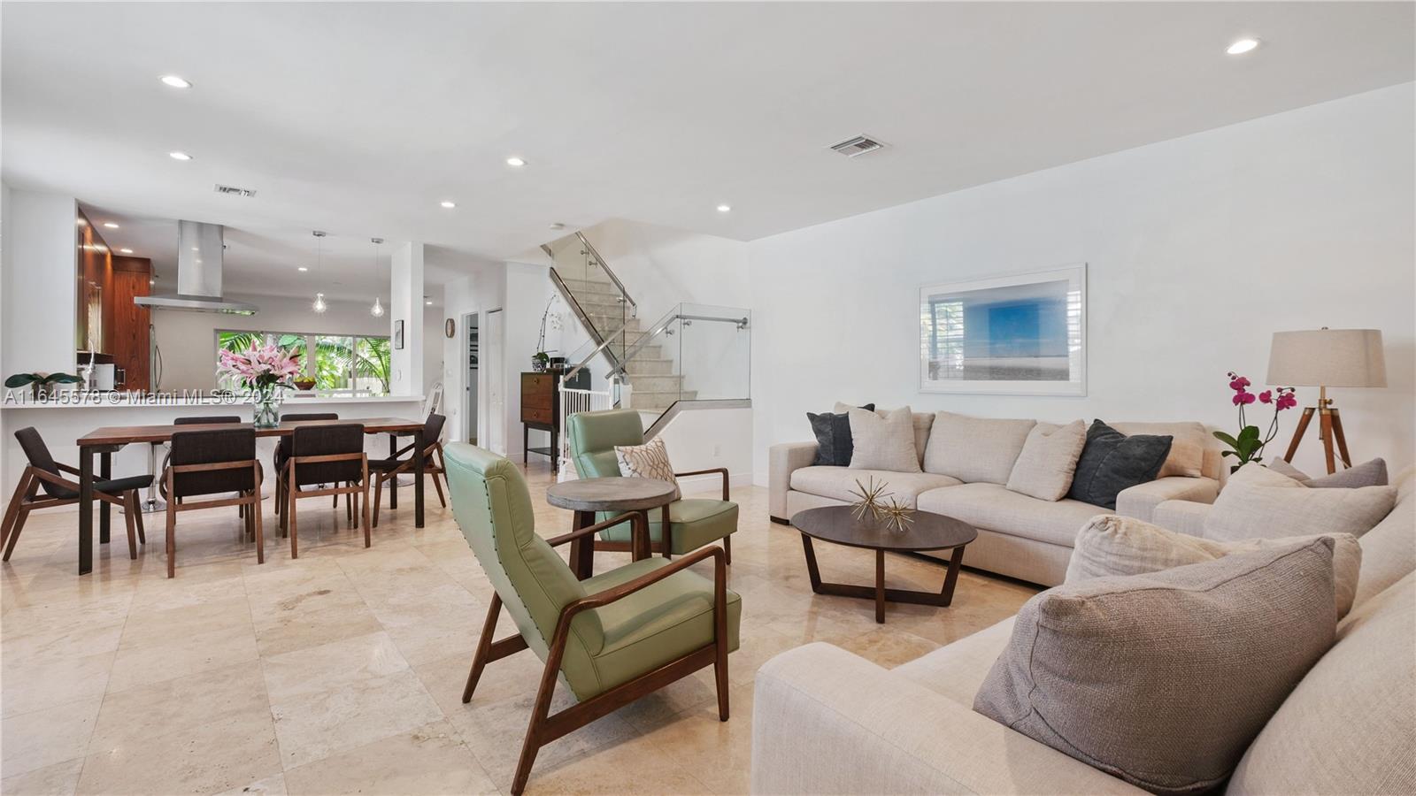 a living room with furniture and a dining table with kitchen view