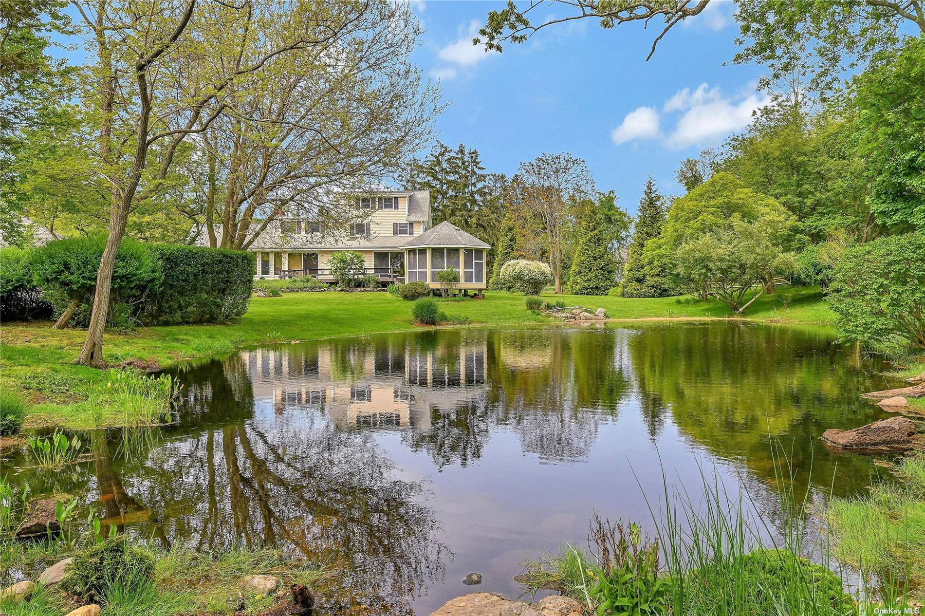 a view of a house next to a lake with a big yard