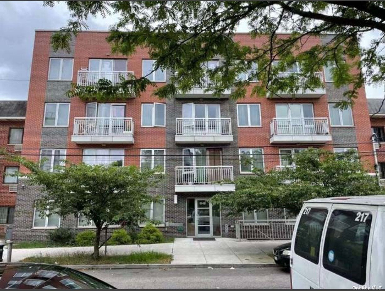 a front view of a residential apartment building with a yard