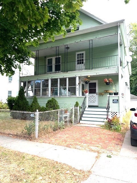 a front view of a house with a yard and potted plants