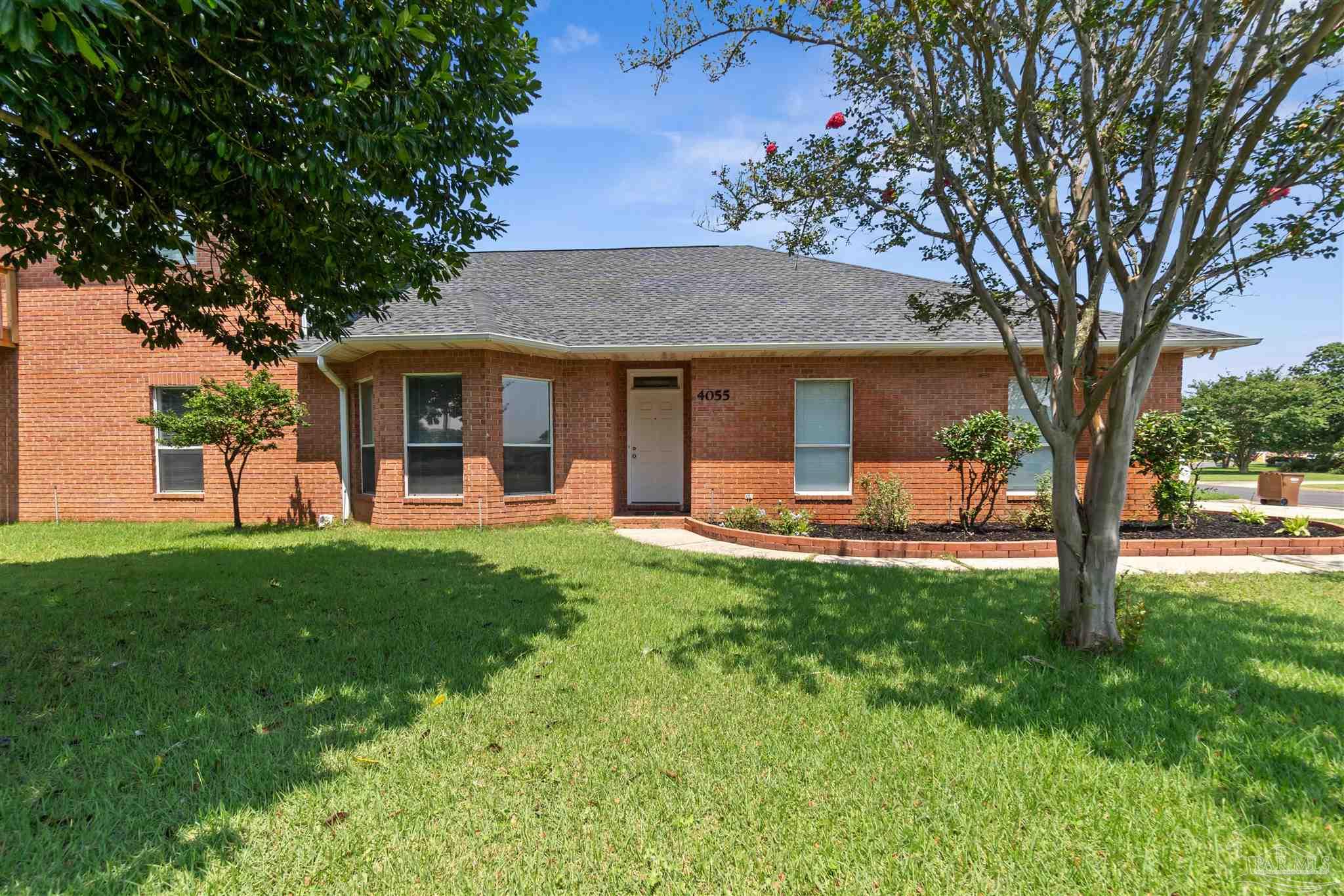 a view of a house with backyard and a tree