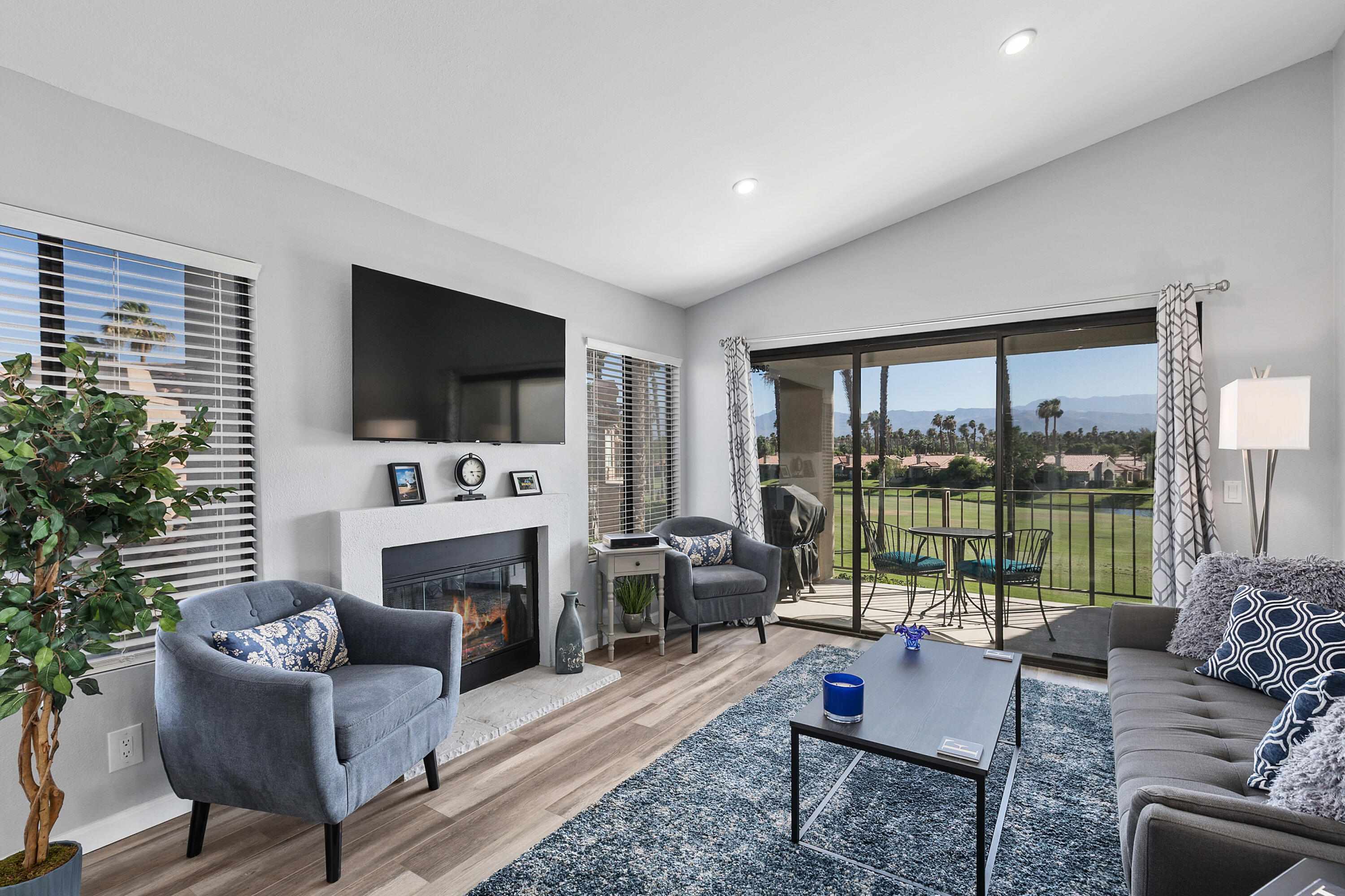 a living room with furniture a flat screen tv and a fireplace