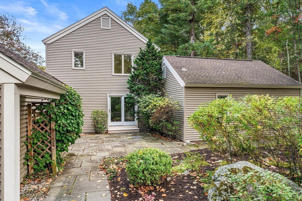 a view of a house with a small yard plants and large tree