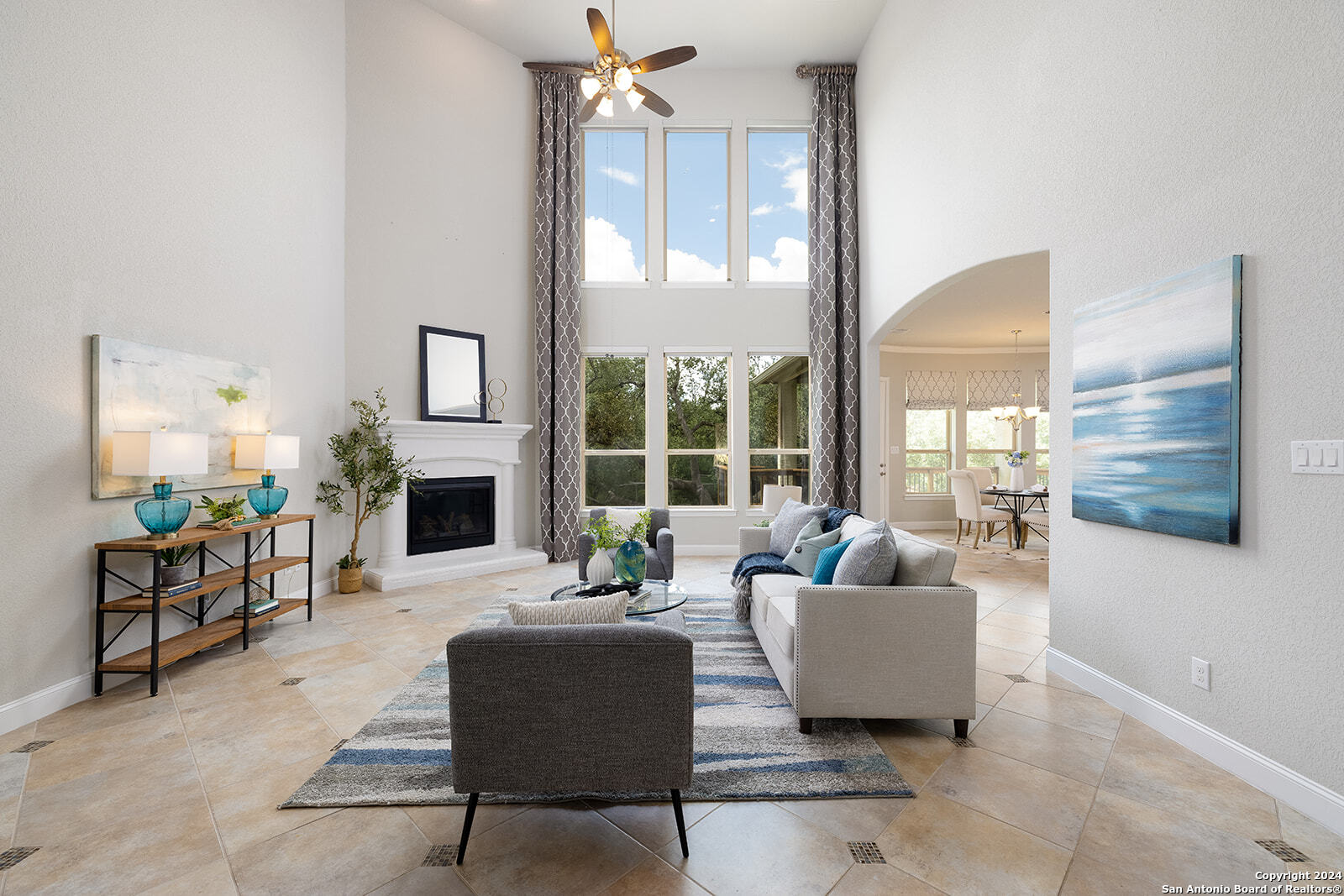 a living room with fireplace furniture and a large window