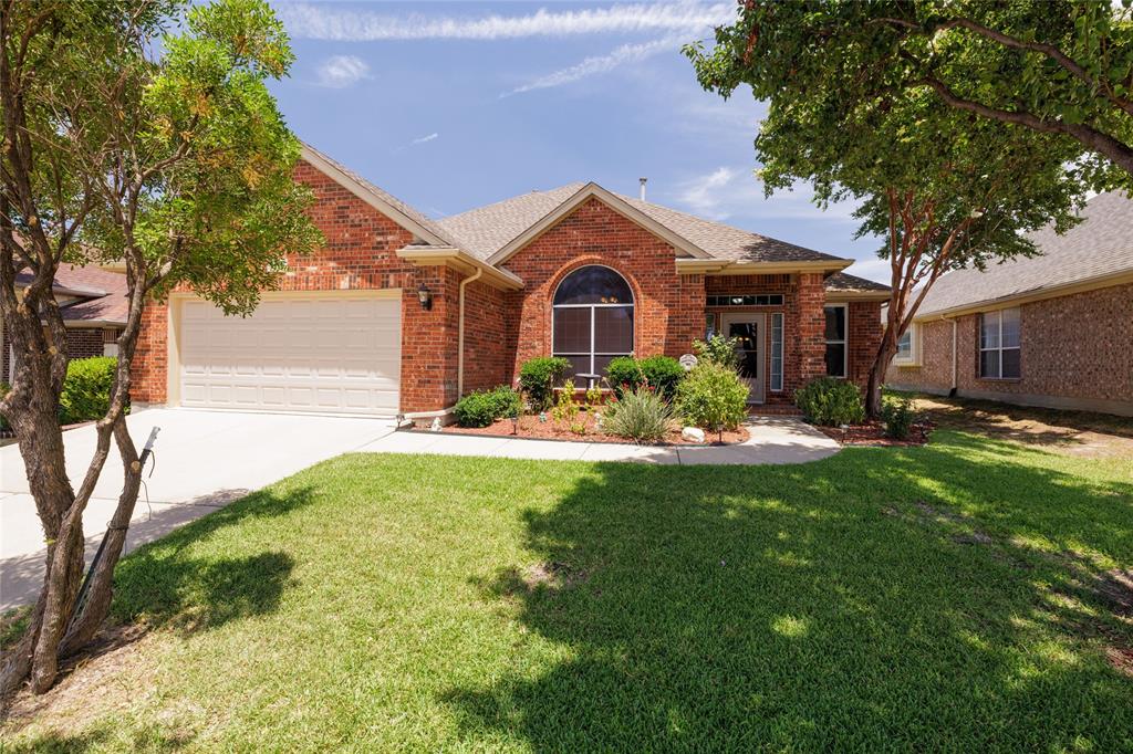 a front view of a house with a yard and a garden