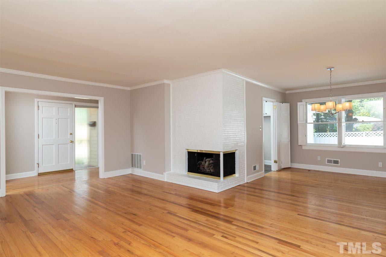 a view of empty room with wooden floor and fireplace