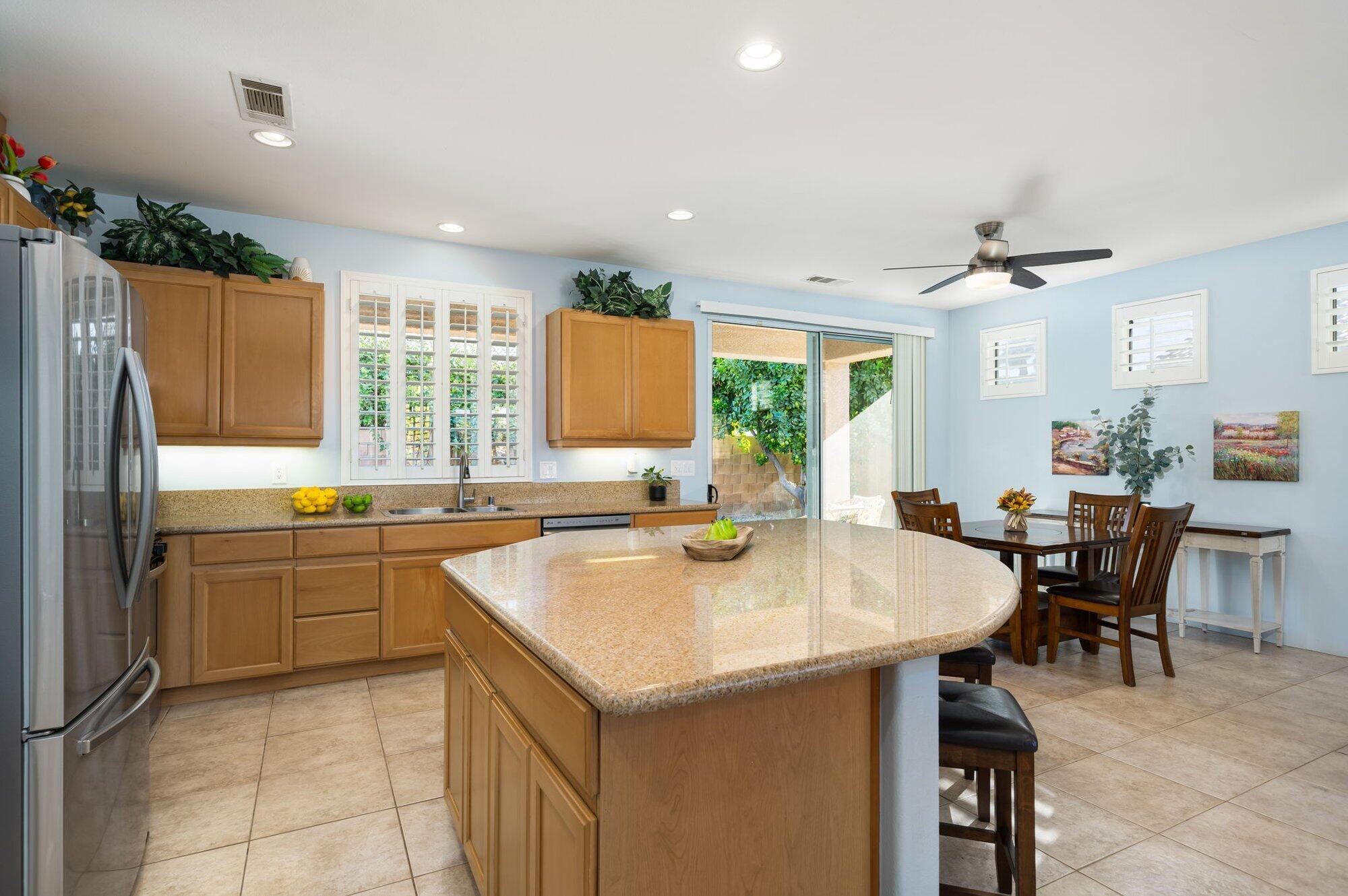 a kitchen with a stove a refrigerator a sink dishwasher with a dining table and chairs