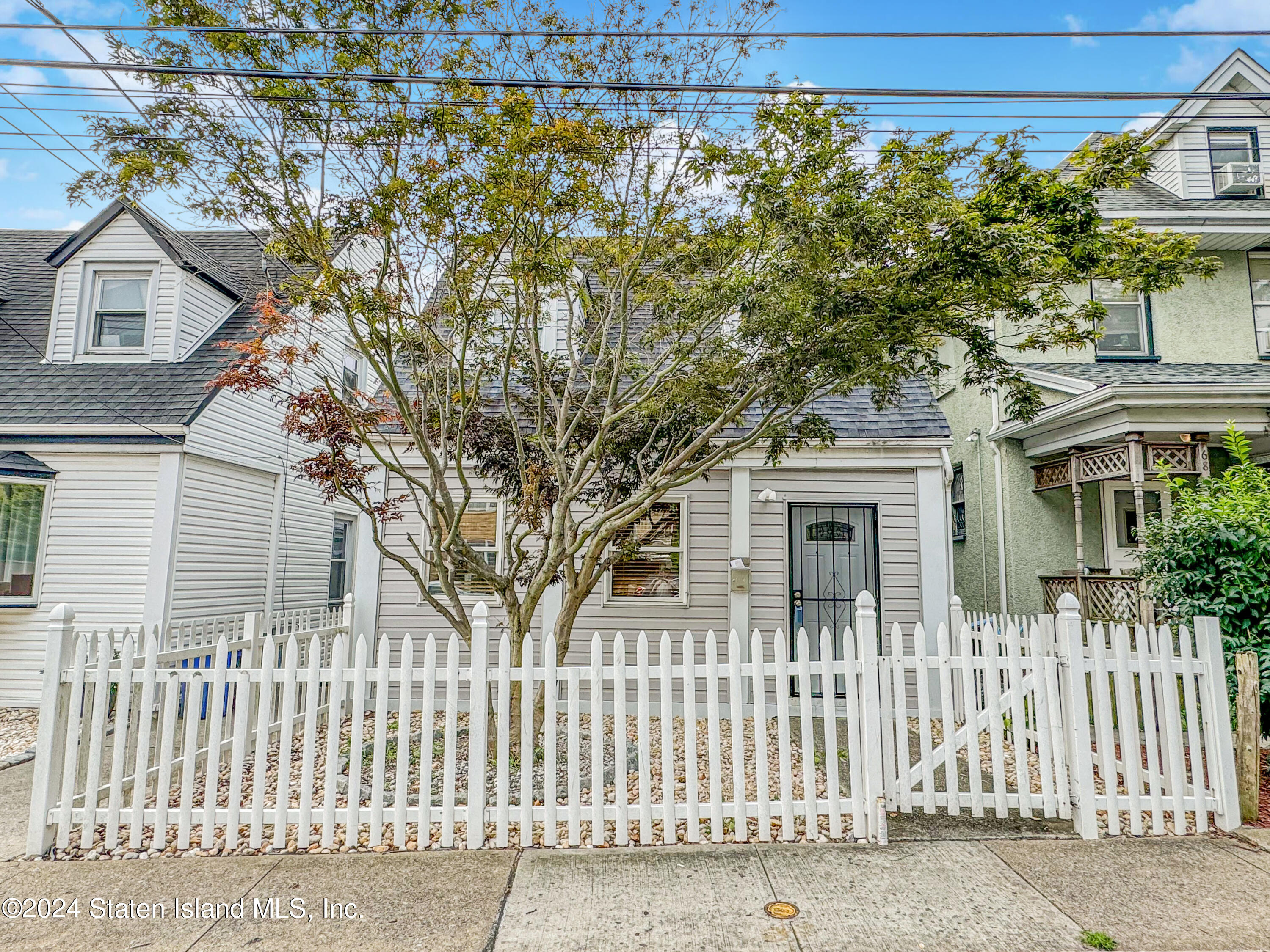 a front view of a house with a tree