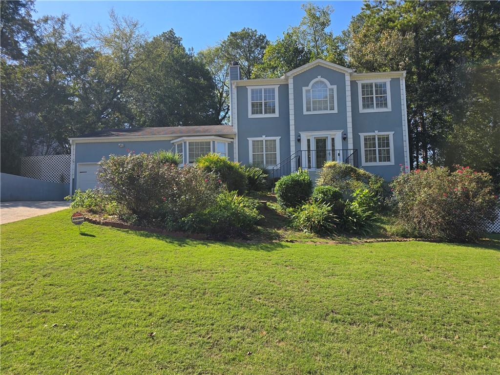 a front view of a house with yard and green space