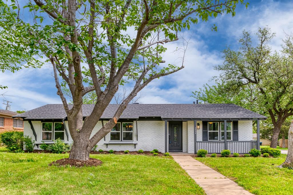 a front view of a house with a yard and trees