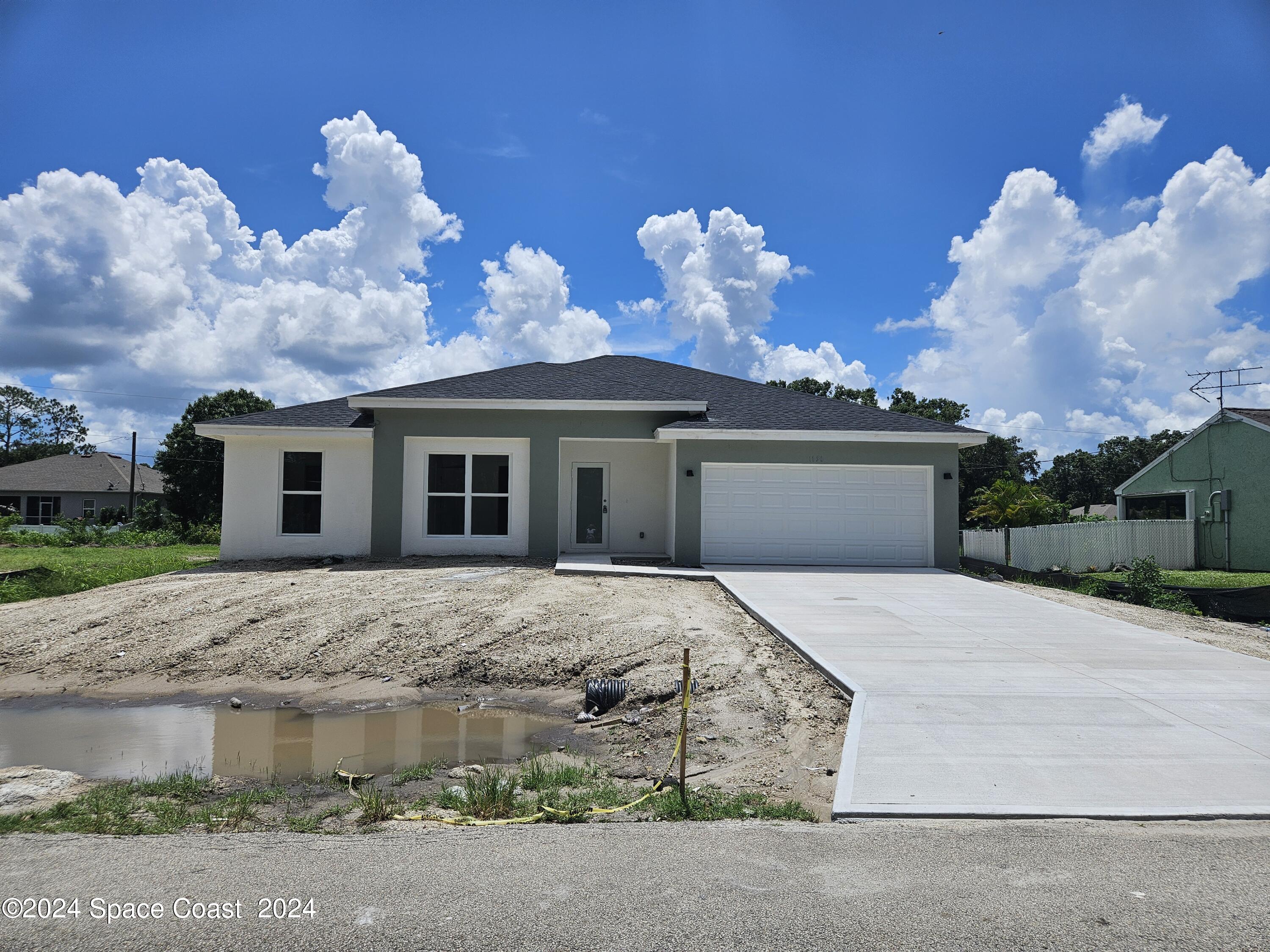 a front view of a house with a yard and a garden