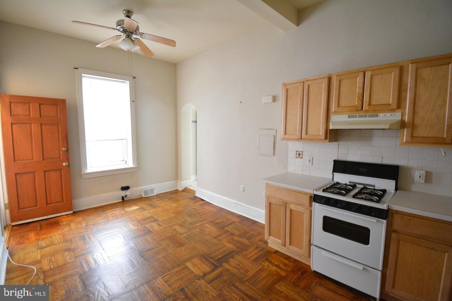 a kitchen with granite countertop a stove a sink and white cabinets