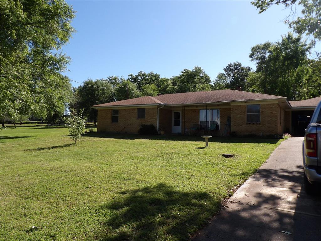 a front view of a house with a yard and trees