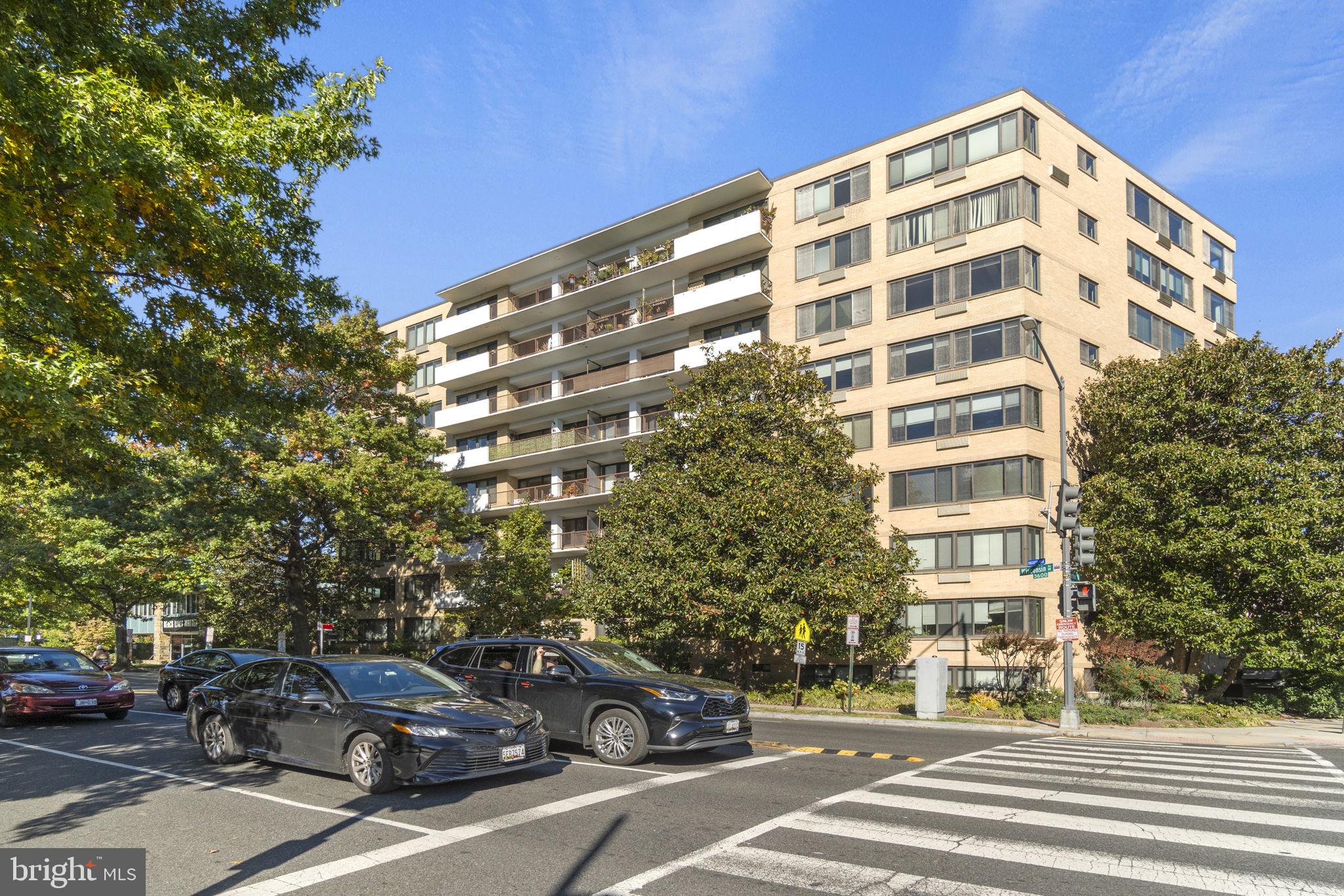 a view of a building and car parked on the side of road