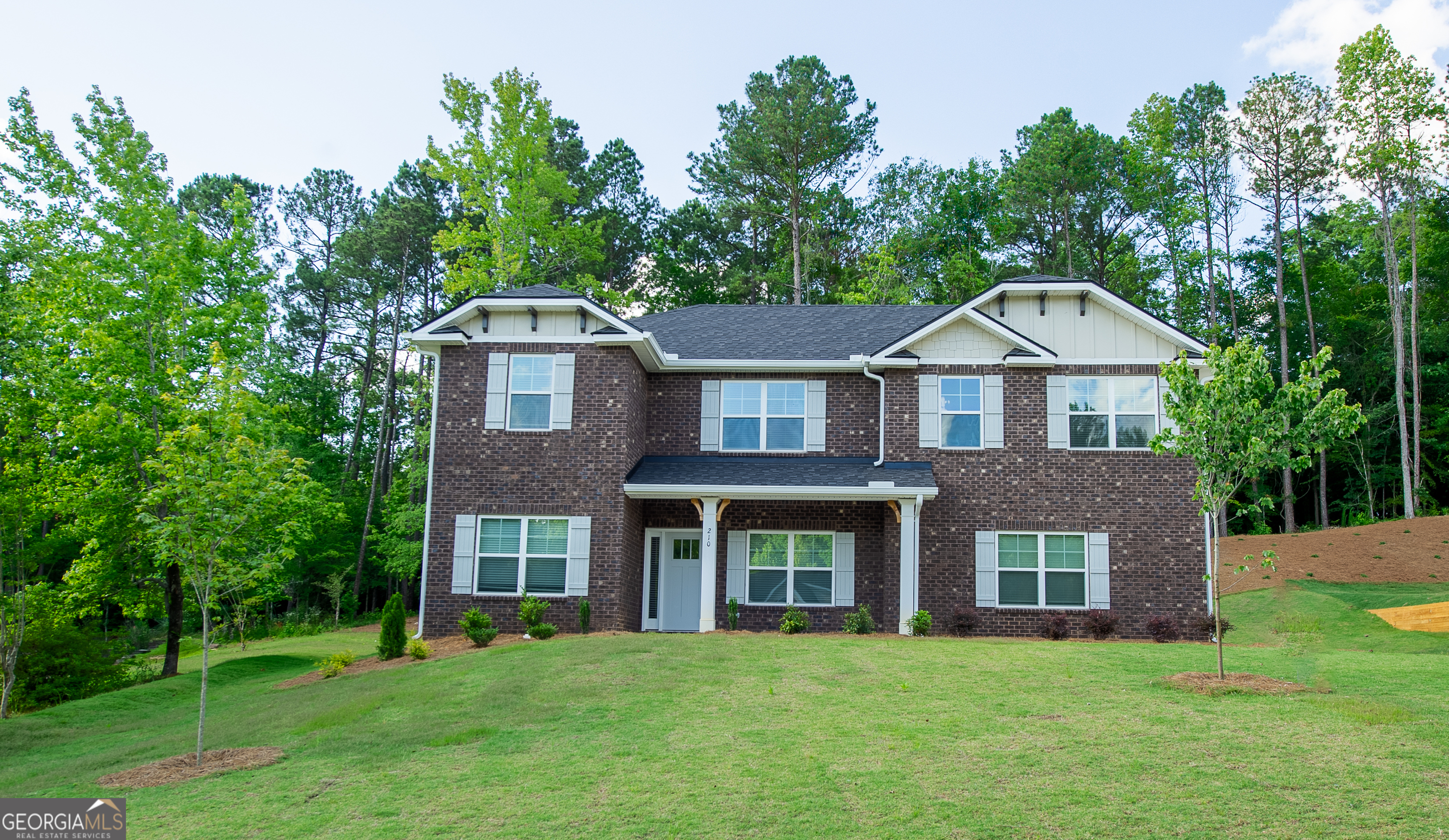 a front view of a house with a garden