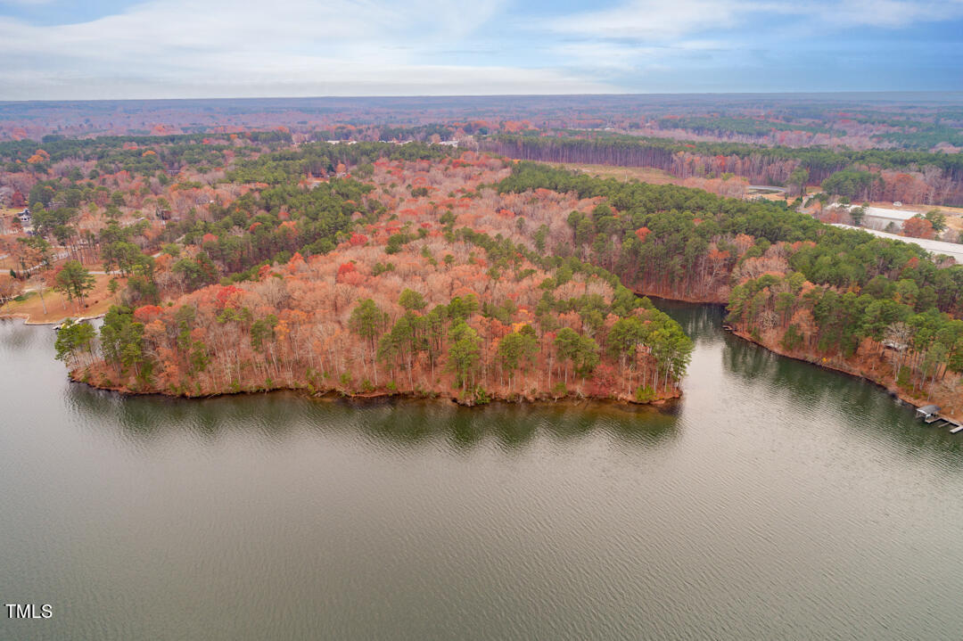 an aerial view of residential houses with outdoor space and lake view