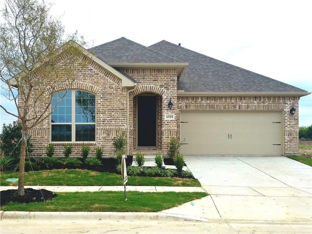 a front view of a house with a garden and plants