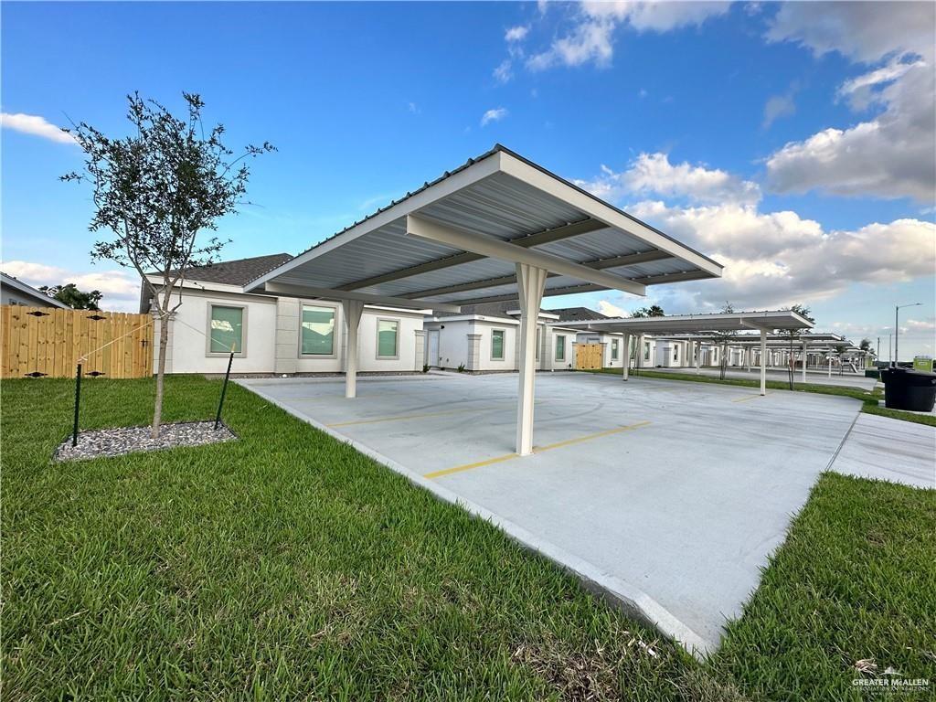 View of car parking with a yard and a carport