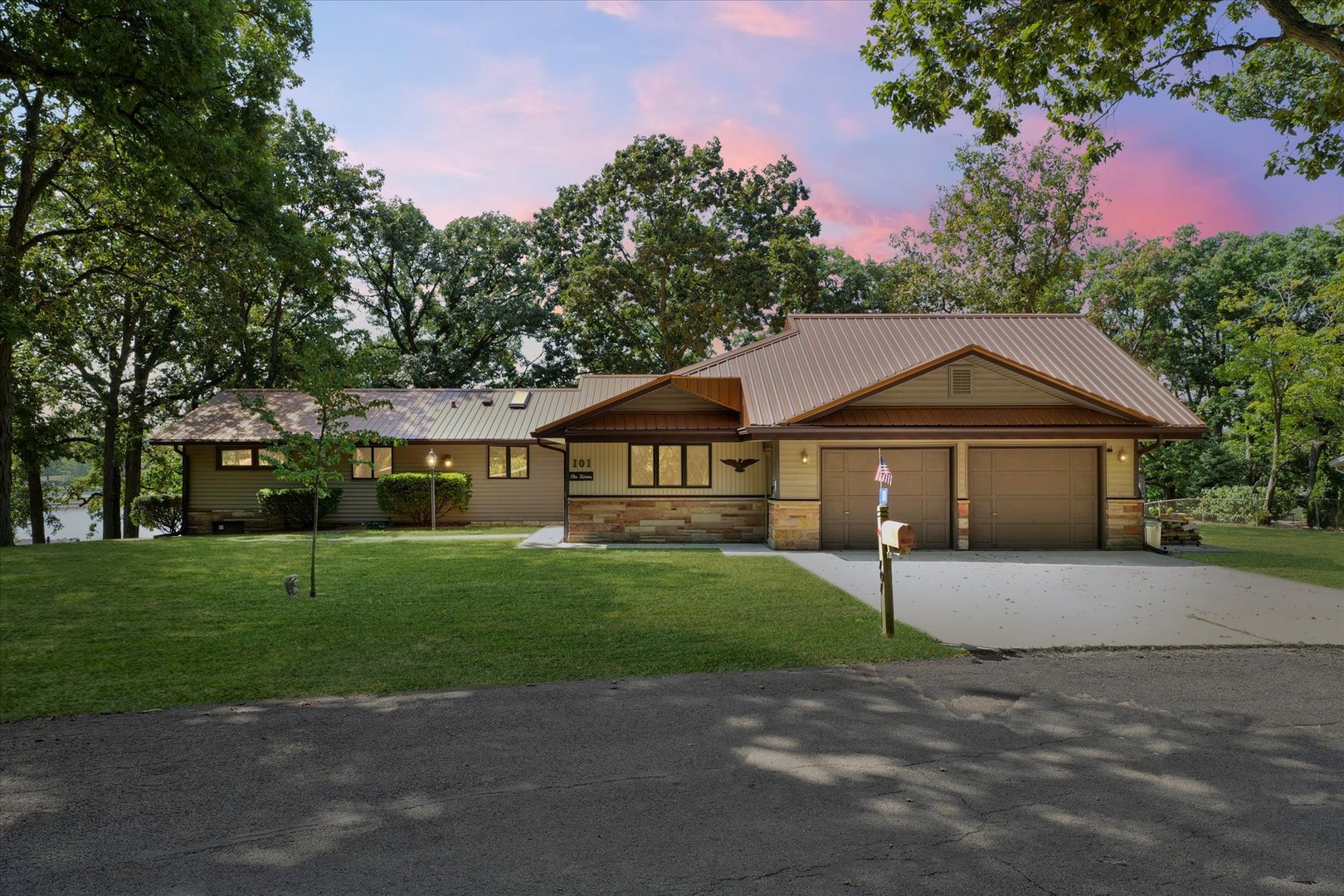 a front view of a house with a garden and trees