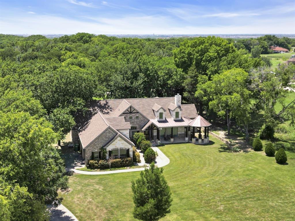 an aerial view of a house with swimming pool and garden