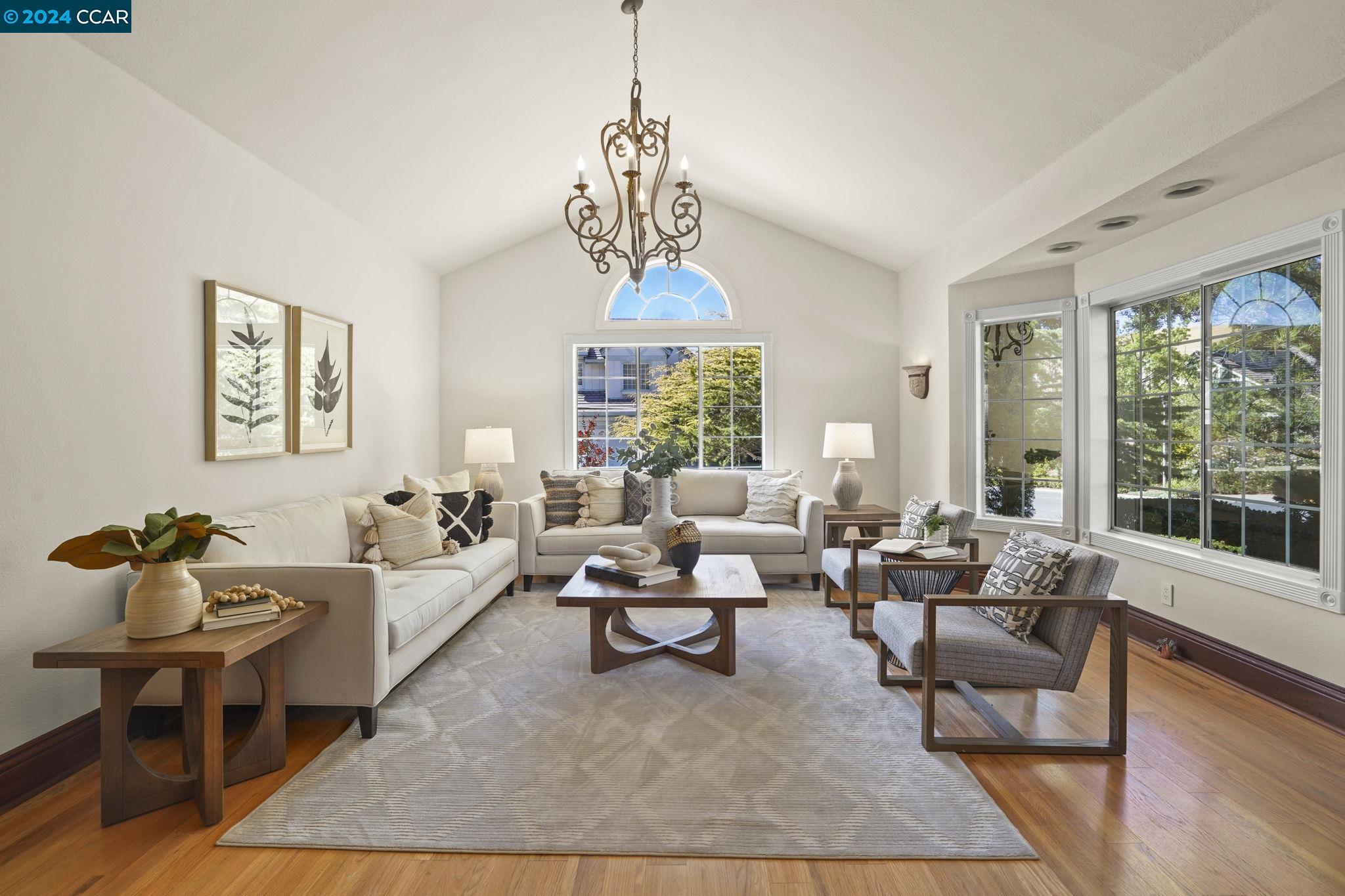 a living room with furniture chandelier and a window