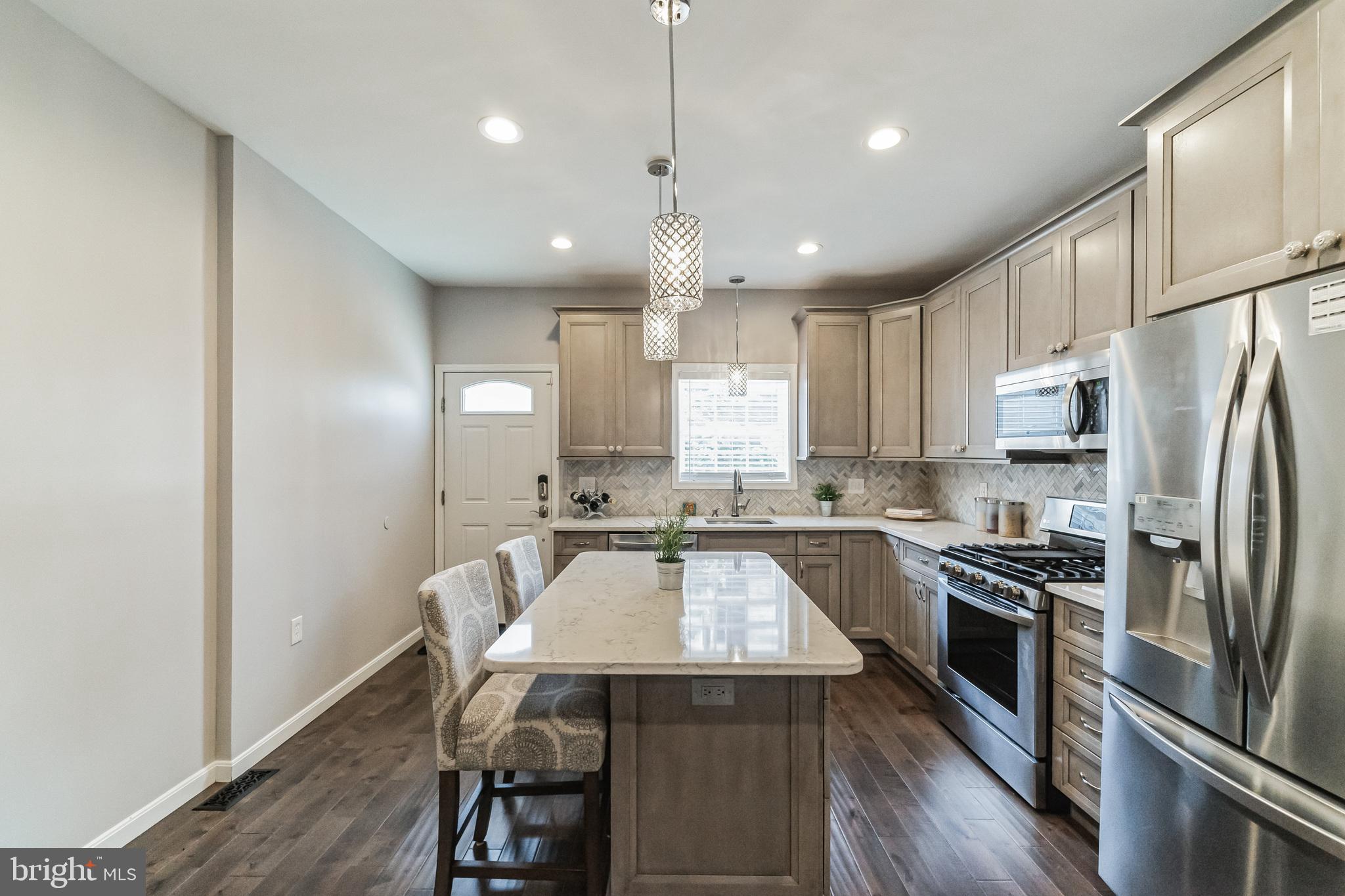 a kitchen with a center island appliances and cabinets